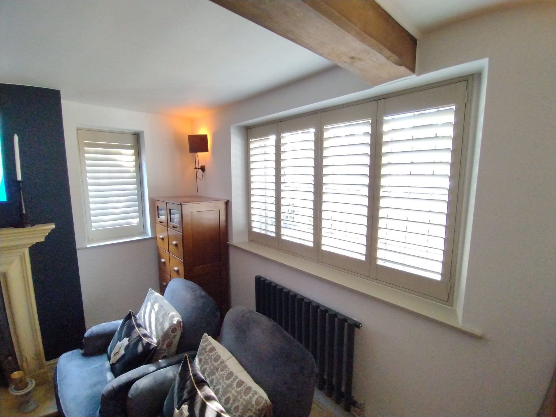Cottage room with two windows dressed in white shutters